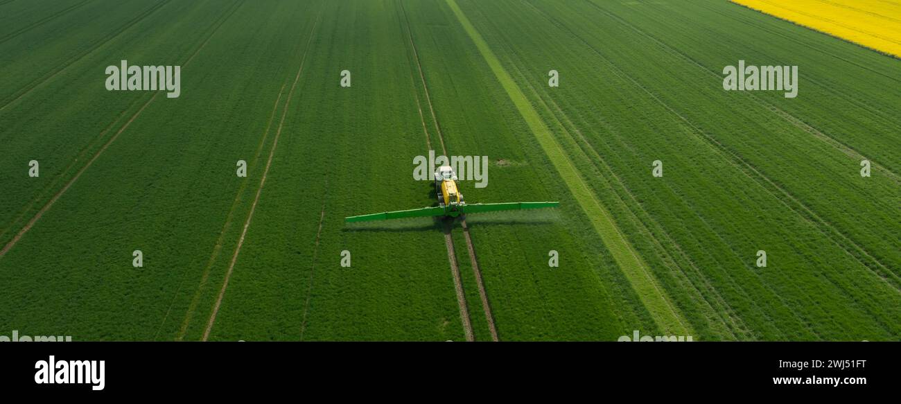 Tractor with field sprayer when applying pesticide against pesticide Stock Photo