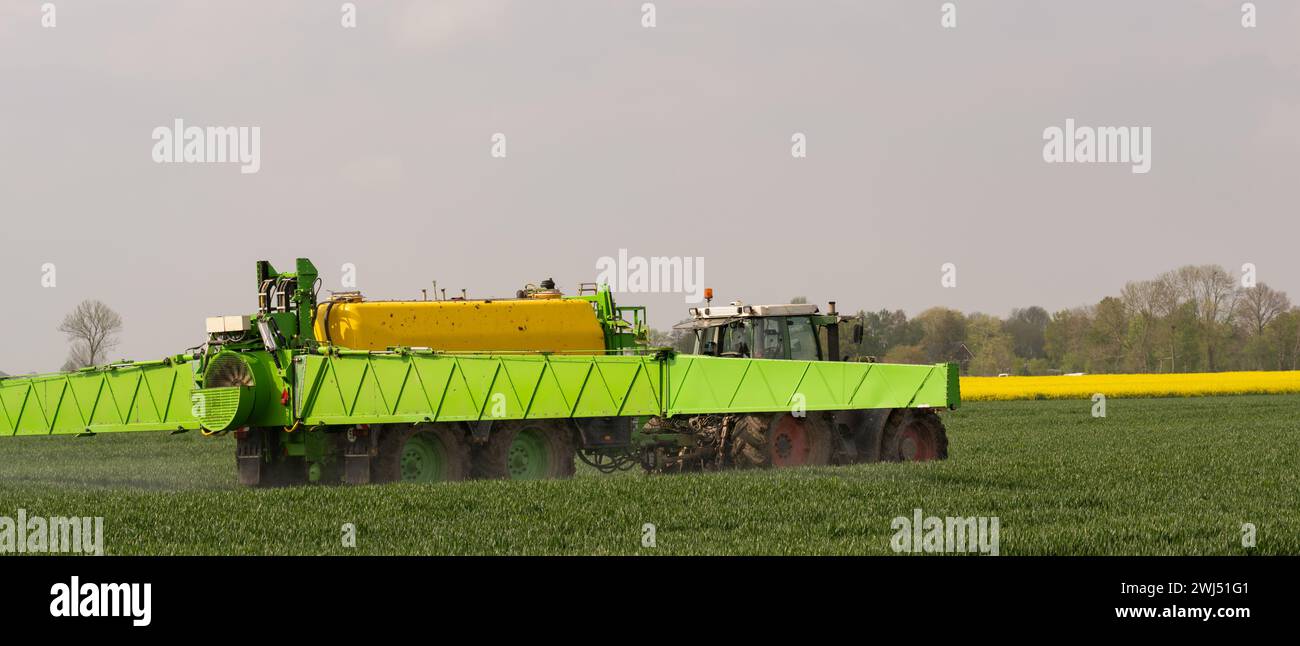 Tractor with field sprayer when applying pesticide against pesticide Stock Photo