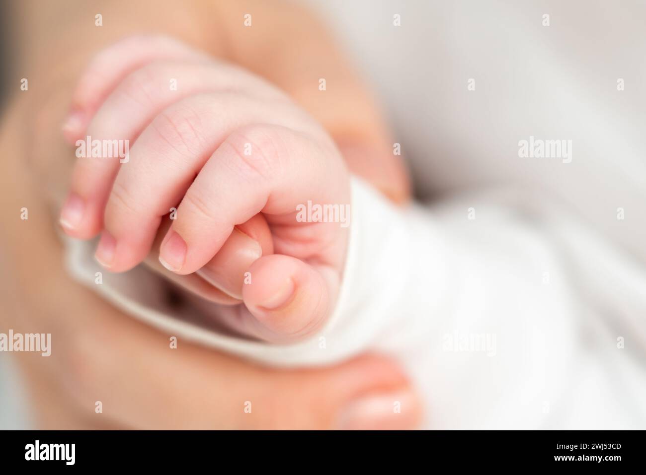 In sleep, newborn clings to maternal warmth. Concept of unbreakable bonds formed early Stock Photo