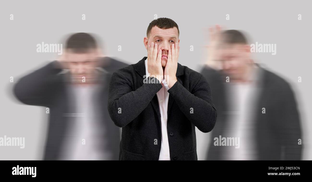 Central man displays disappointment and desperation amid blurry anger and madness. Concept of internal emotional battle Stock Photo
