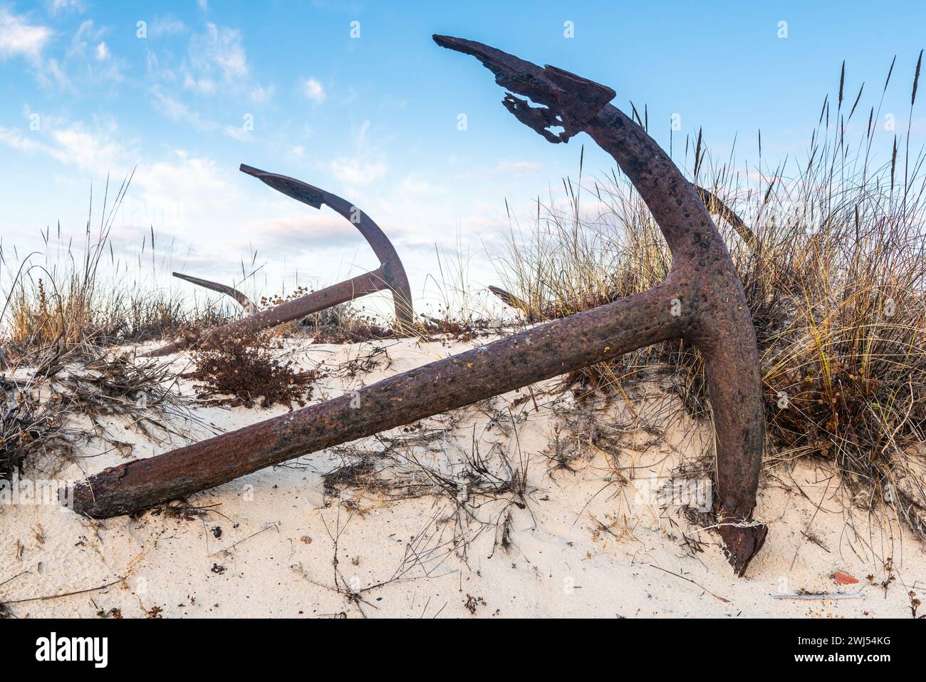 Rusty old anchors on the beach at the Anchor Cemetary graveyard at Praia do Barril beach, in Tavira, Algarve, Portugal Stock Photo