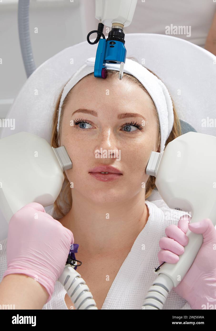 Cosmetology image of hands of several doctors holding laser equipment over female face. Beauty and Cosmetology concept Stock Photo