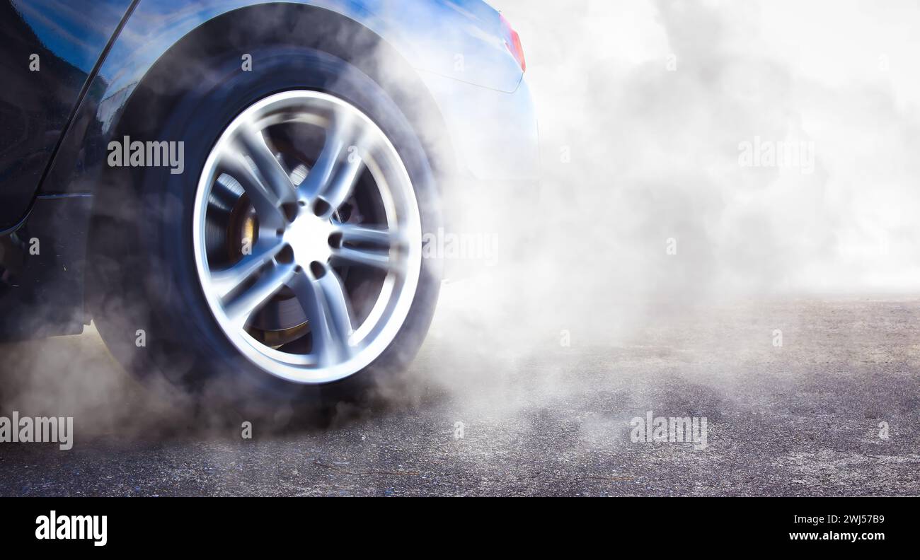 The wheels of the race car spin at speed on track and are covered with