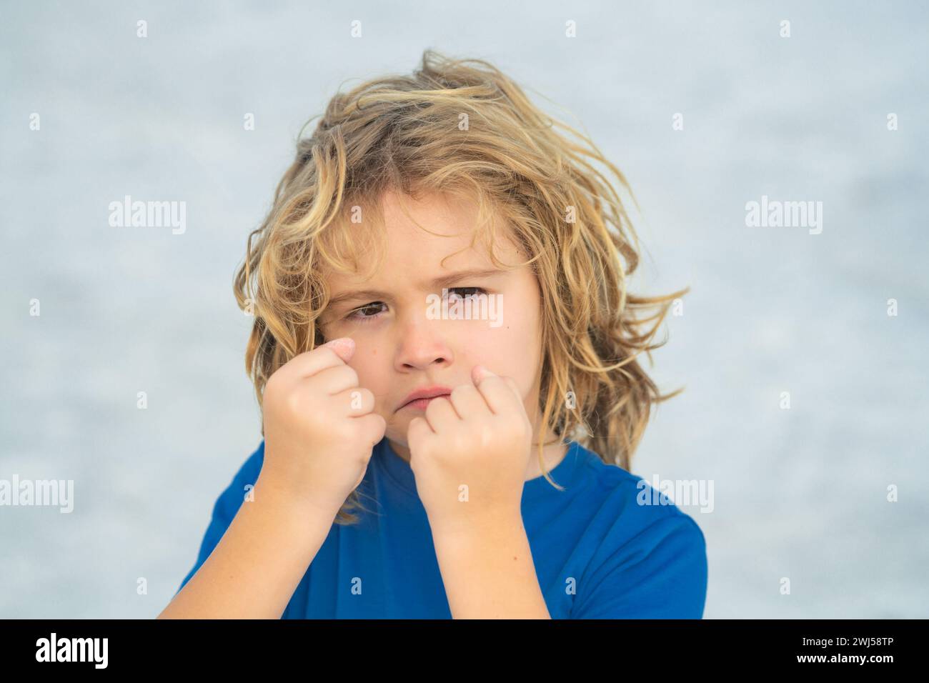 Child temper with angry expression. Angry hateful little anger boy, child furious. Angry rage kids face close up. Anger child with furious negative Stock Photo