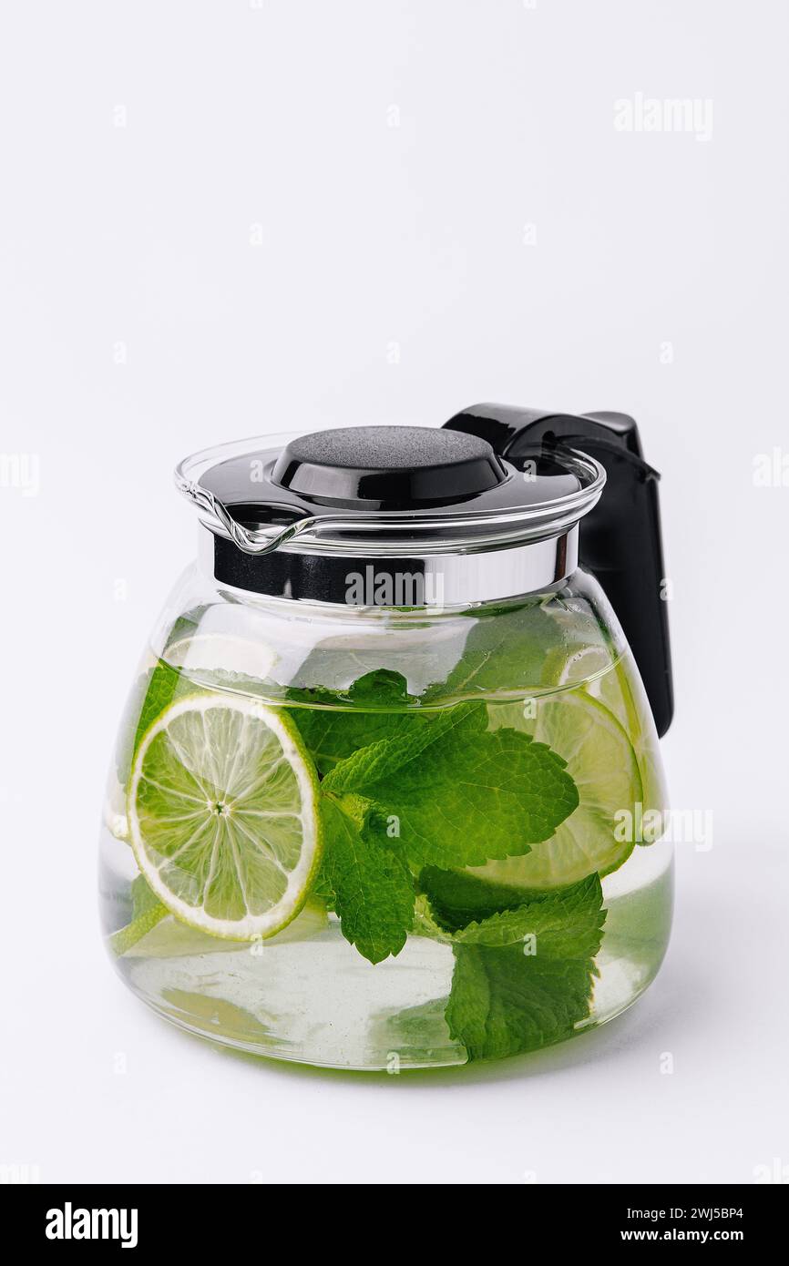 Fruit water with lime and mint in glass pitcher Stock Photo