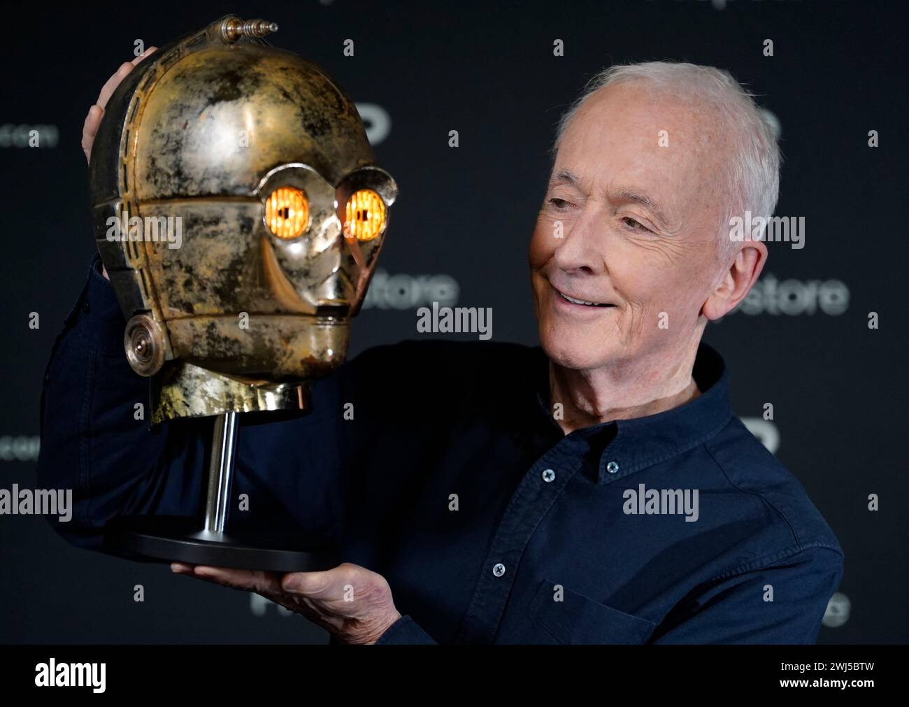 Actor Anthony Daniels looks at his C-3PO head from his costume for the 1983 film 'Star Wars: Episode VI - Return of the Jedi' during a photocall at the Propstore in Rickmansworth, Hertfordshire. The head is estimated to sell for between $500,000 and $1 million when it goes under the hammer in Los Angeles this month, along with other items from his personal Star Wars memorabilia collection. Picture date: Wednesday January 17, 2024. Stock Photo