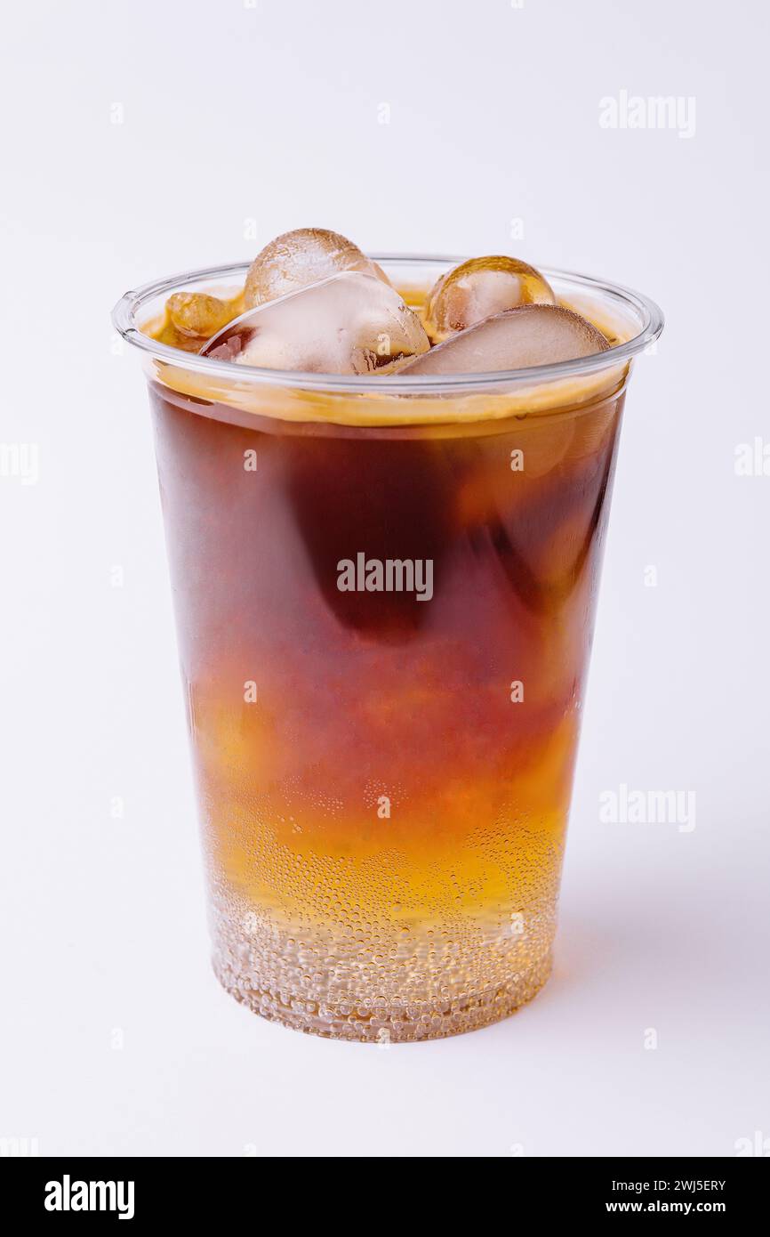 Cola with ice in plastic glass on white background Stock Photo - Alamy