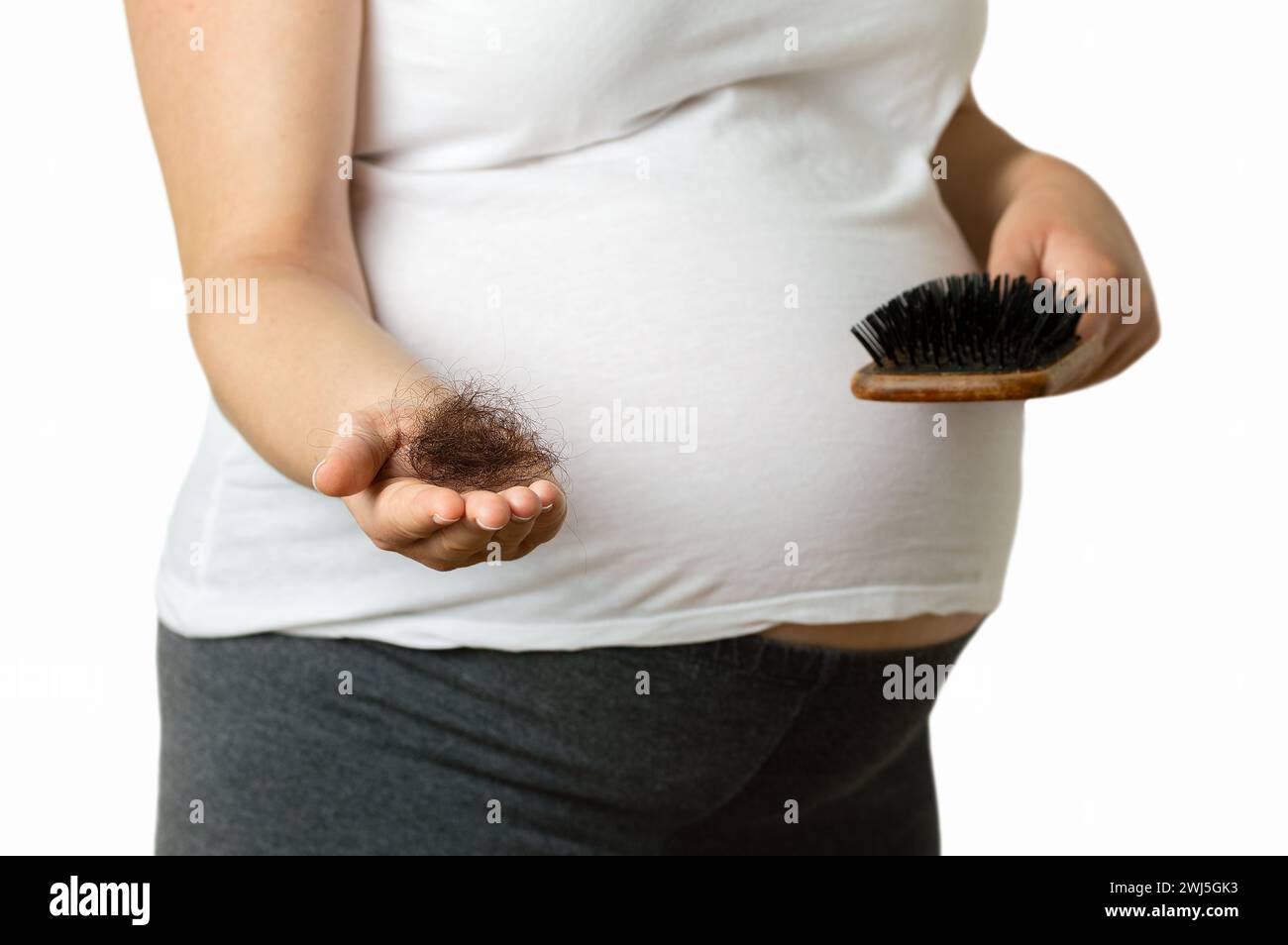 Pregnant woman hand palm holding a hairs and a comb with white background Stock Photo