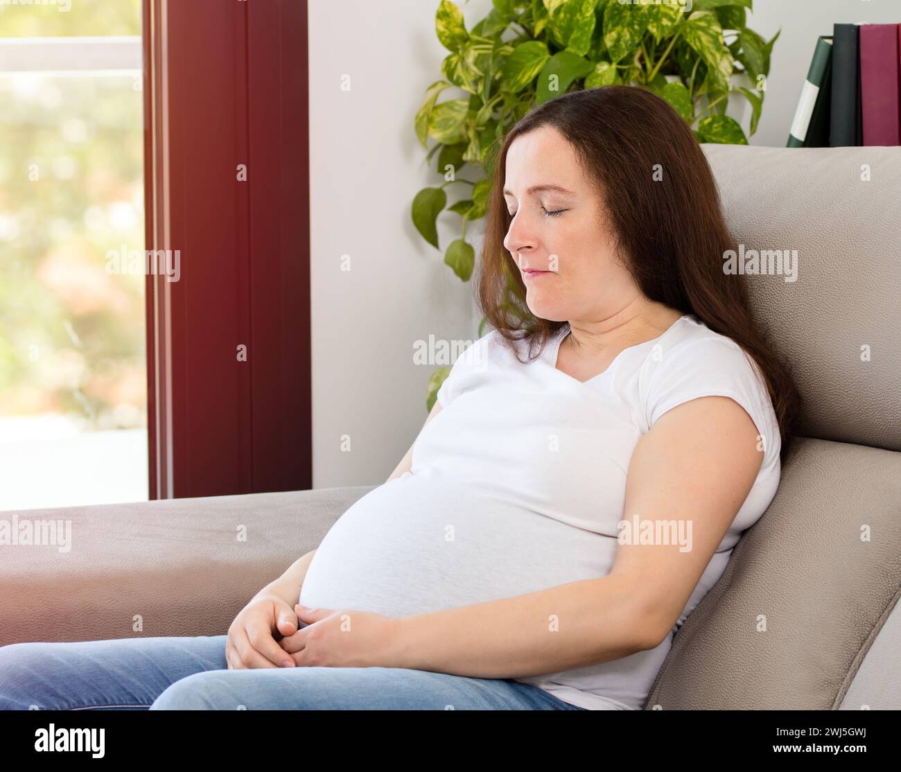 Happy relaxed woman resting on a couch at home Stock Photo