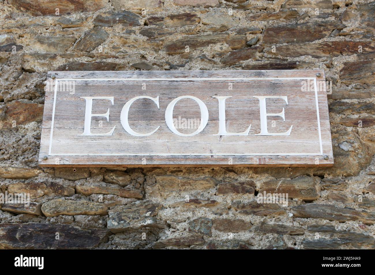 School signboard on a wall called ecole in French language Stock Photo