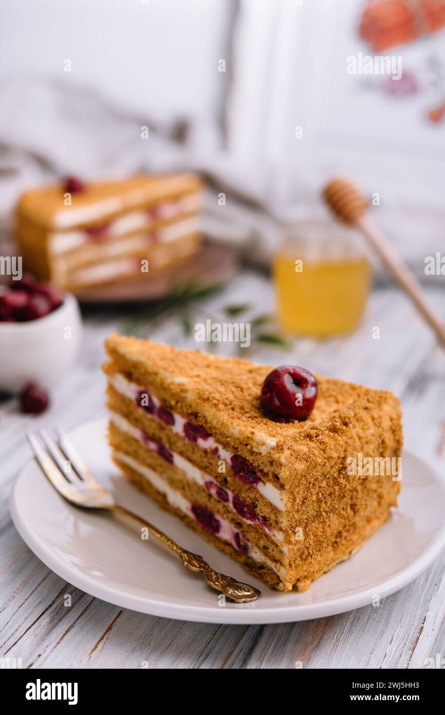 Homemade honey cake with cherry on plate Stock Photo