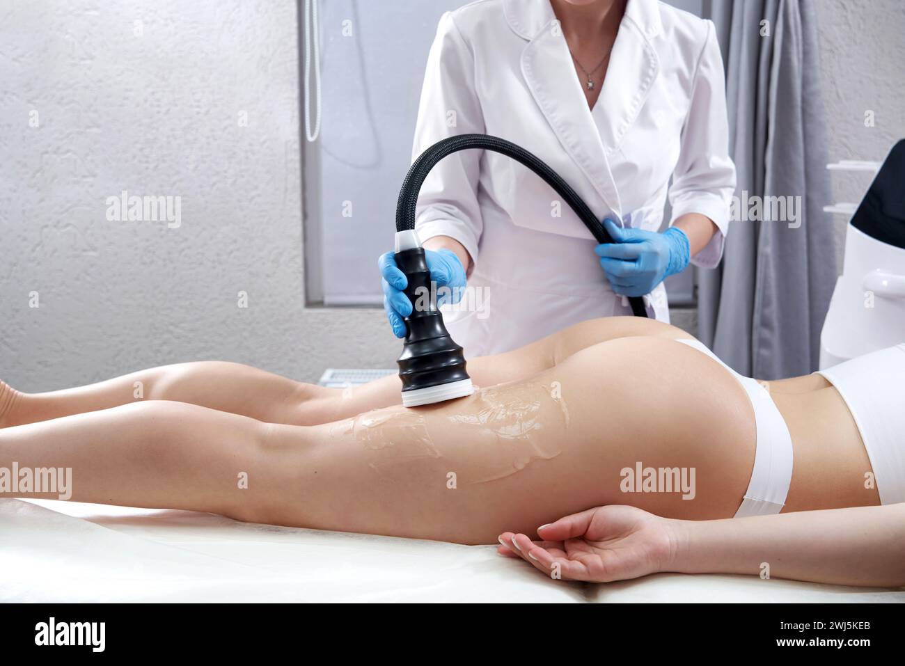 Ultrasound cavitation body contouring treatment. Woman getting anti-cellulite and anti-fat therapy in beauty salon Stock Photo