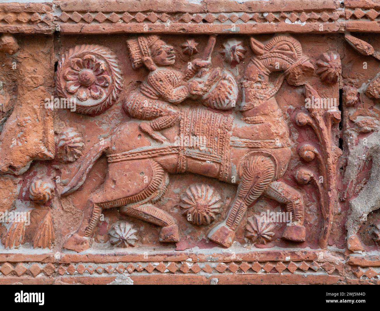 Closeup view of carved terracotta scene of man riding horse on ancient Govinda temple in Puthia religious complex, Rajshahi, Bangladesh Stock Photo