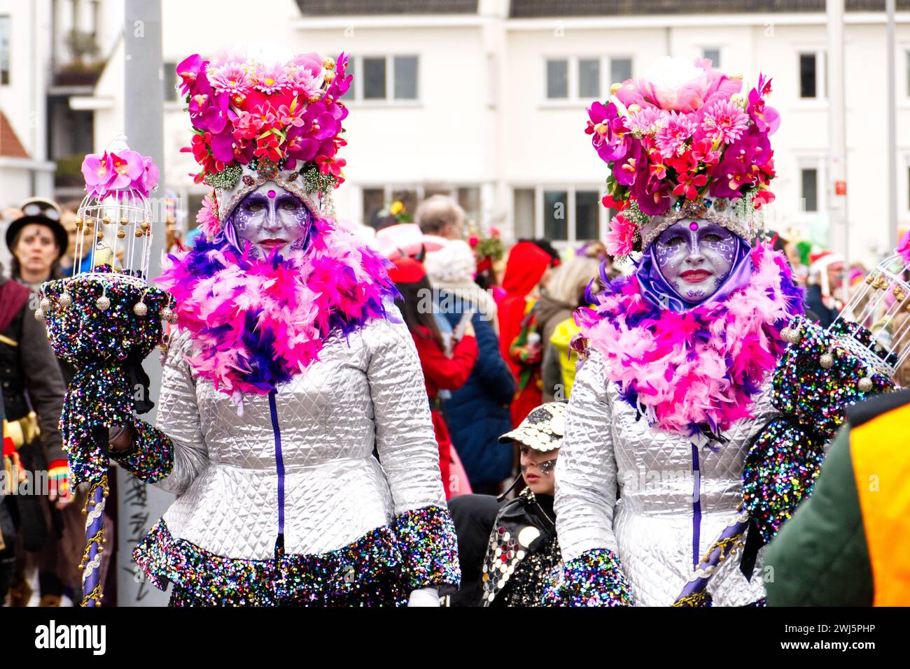 Maastricht, The Netherlands. 11th February 2024. Two women with matching colourful face paint and striking costumes taking part in the parade in Maastricht on Carnival Sunday. Anna Carpendale/Alamy Live News Stock Photo