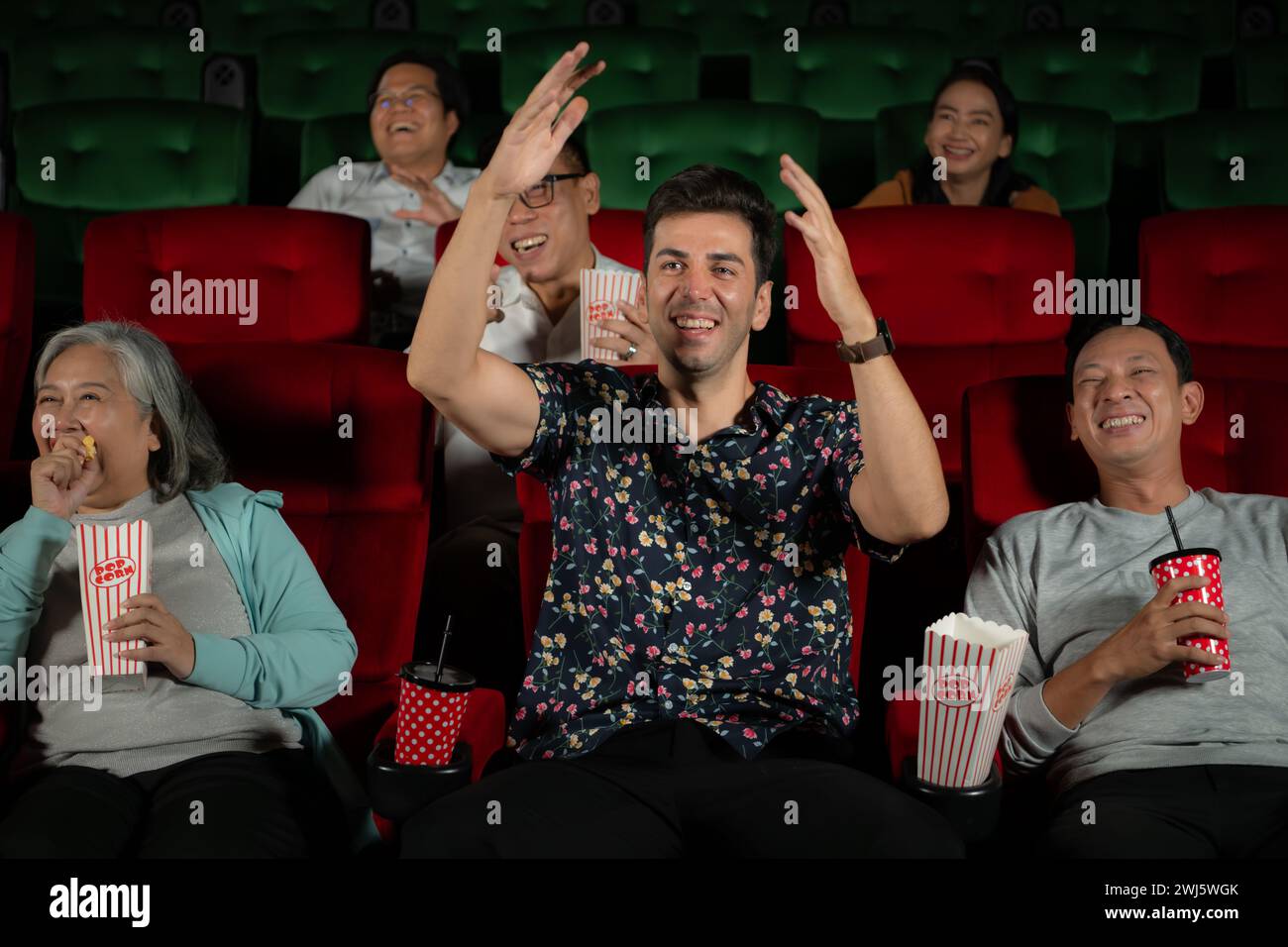 Group of asian senior friends watching comedy movie and laugh at the cinema with popcorn Stock Photo