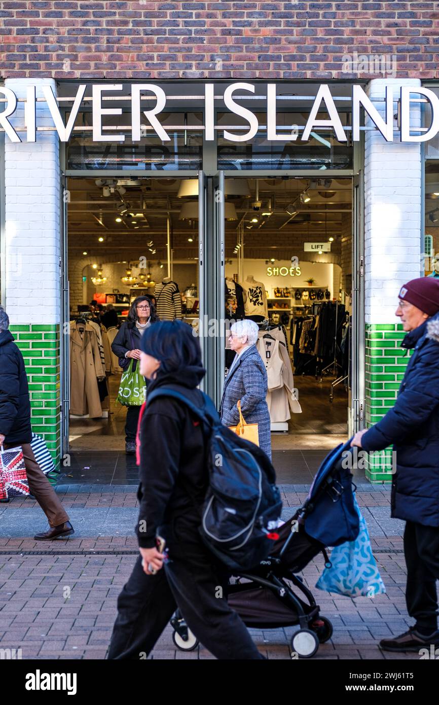 Kingston-Upon-Thames, London UK, February 12 2024,  People Walking Past A High Street Branch Of A River Island Fashion Clothing Shop Stock Photo