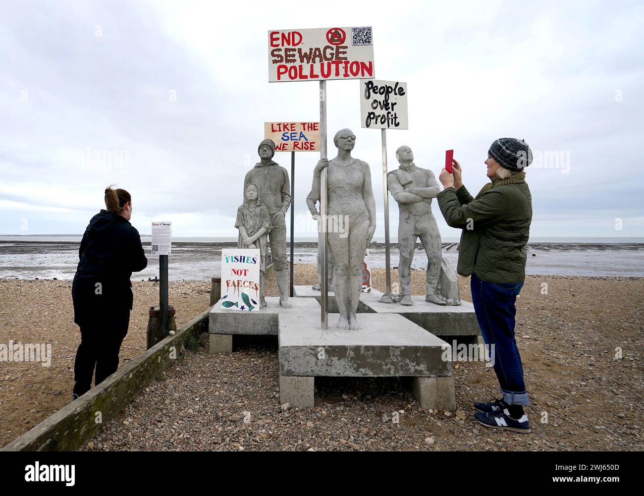 A view of art installation, Sirens of Sewage, by Jason DeCaires Taylor unveiled on the beach in Whitstable, Kent, portraying a small cross-section of the local Whitstable community, a cold water swimmer, a school child, kite surfer, a lifeboat volunteer and a local fisherman. The art installation is intended to celebrate these people who are part of a national network of volunteers, driving public discourse and political action to safeguard the health of our water bodies and marine ecologies. Picture date: Tuesday February 13, 2024. Stock Photo