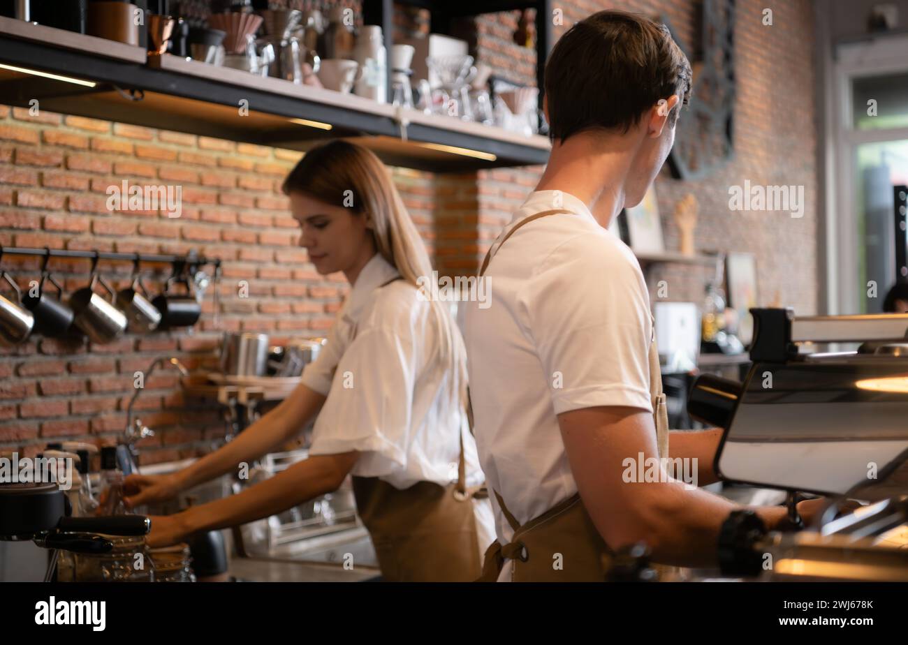 Barista working in cafe. Portrait of young male barista standing behind counter in coffee shop. Stock Photo