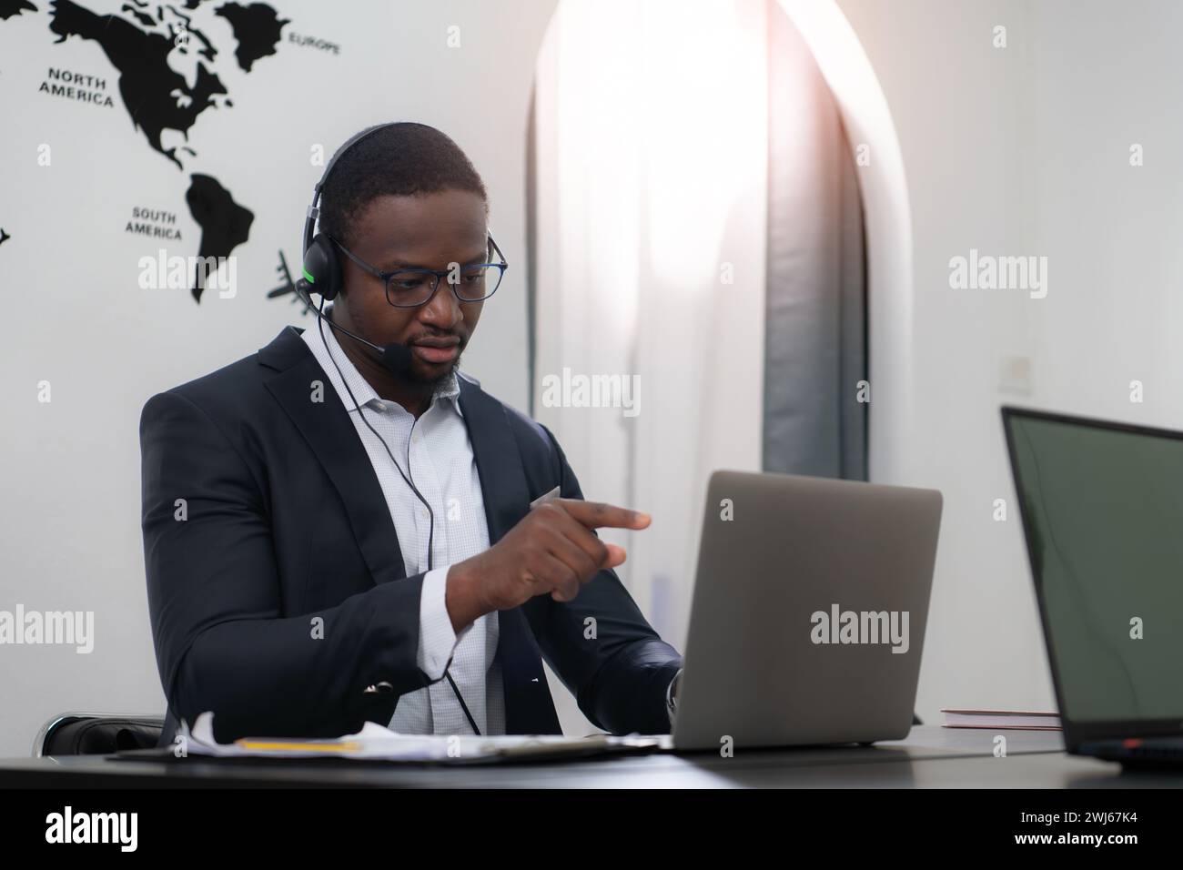 Portrait of business people wearing headset working actively in office. Call center, telemarketing, customer support agent provi Stock Photo