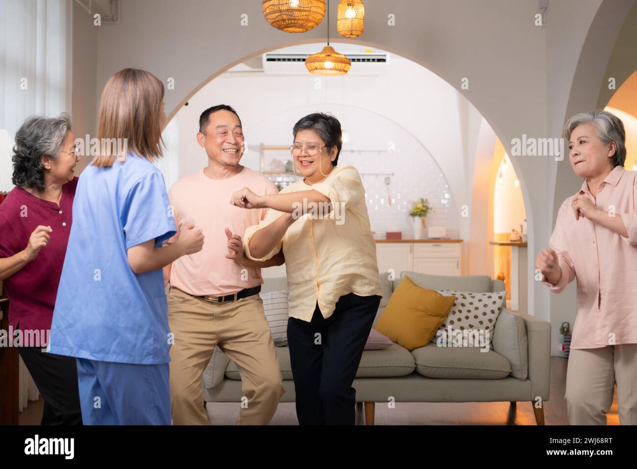 A group of elderly Asian people dance together happily, in the retirement home Stock Photo