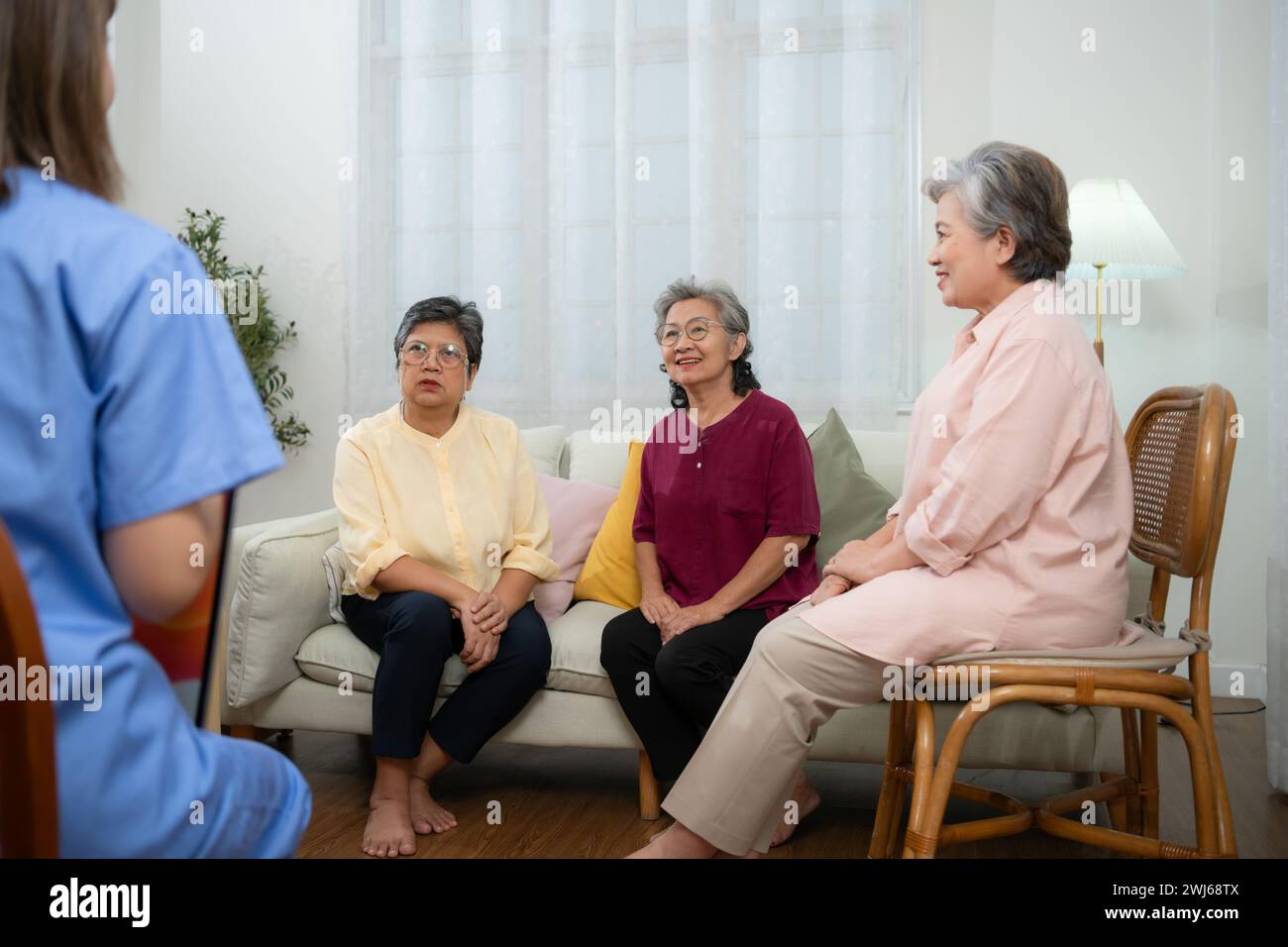Group of elderly and Asian senior man having a conversation with nurse in the retirement home Stock Photo