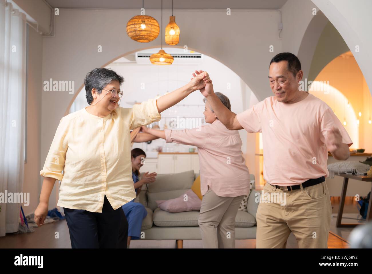 A group of elderly Asian people dance together happily, in the retirement home Stock Photo