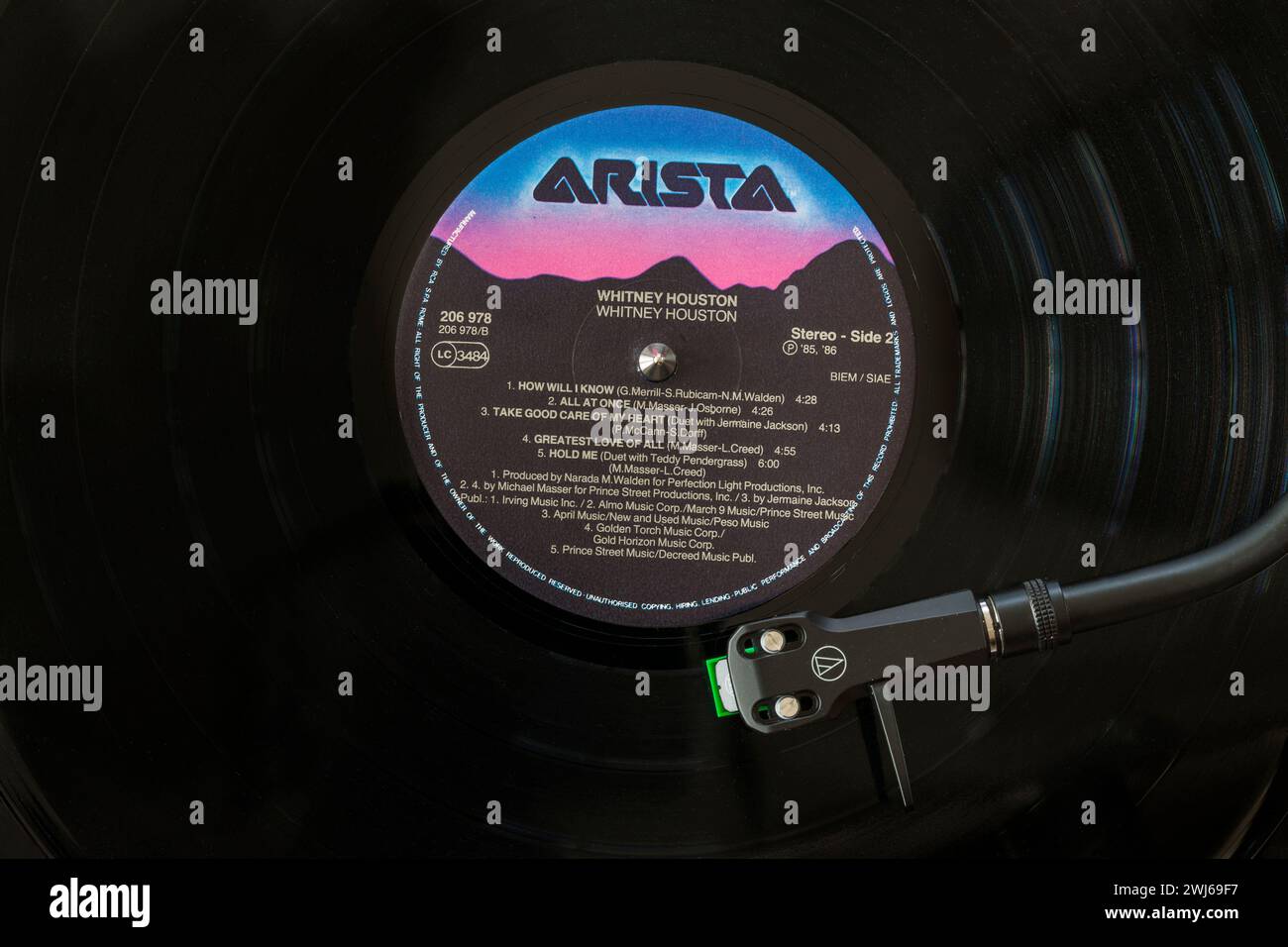 Whitney Houston vinyl record album LP with tonearm, cartridge, headshell and stylus on turntable record player - 1985 Stock Photo