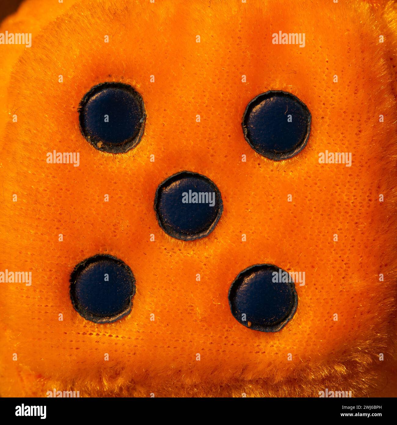Top view of one side of orange fluffy dice. Close up as a background. Stock Photo