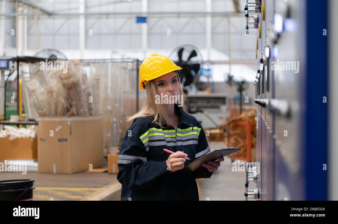 Female engineers check the operation of the machine's circuit board. Stock Photo