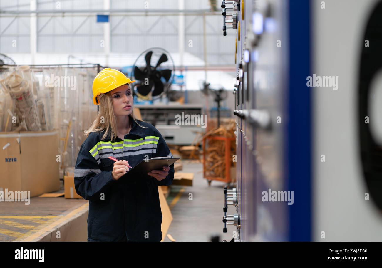 Female engineers check the operation of the machine's circuit board. Stock Photo