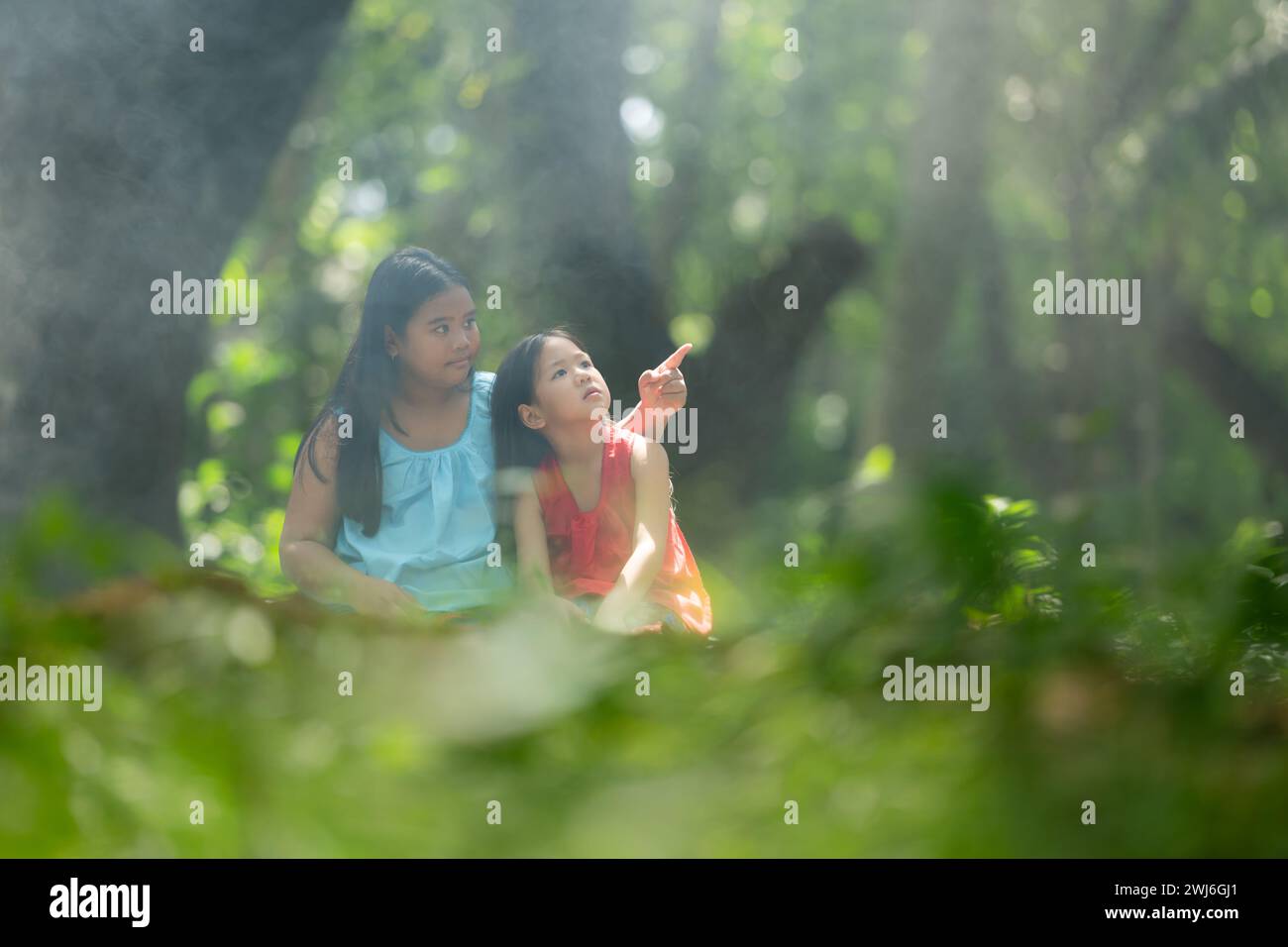 Two girls Asian women with traditional clothing stand had fun playing together in the rainforest. Stock Photo