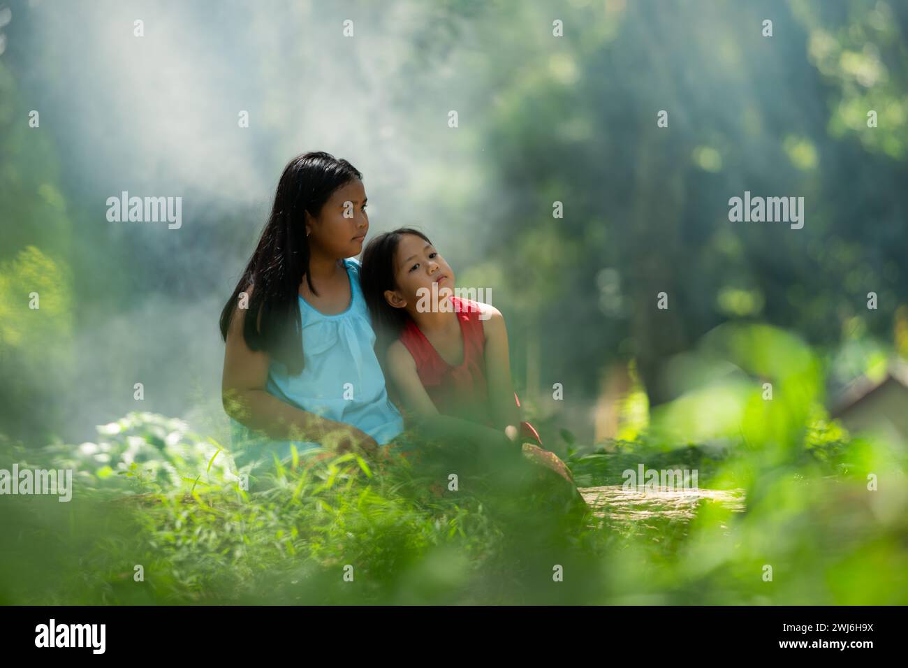 Two girls Asian women with traditional clothing stand had fun playing together in the rainforest. Stock Photo