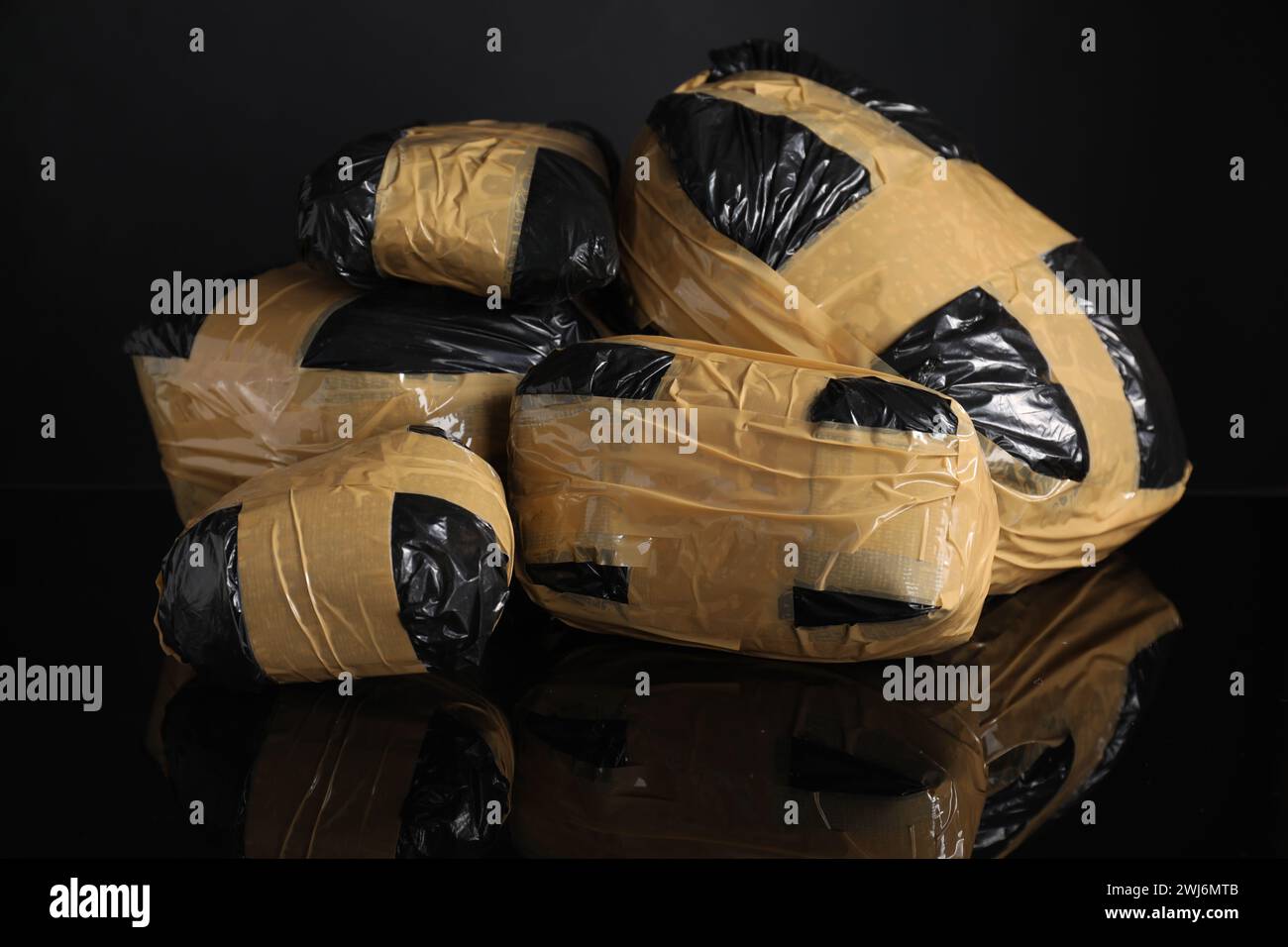 Smuggling and drug trafficking. Packages with narcotics on black mirror surface Stock Photo