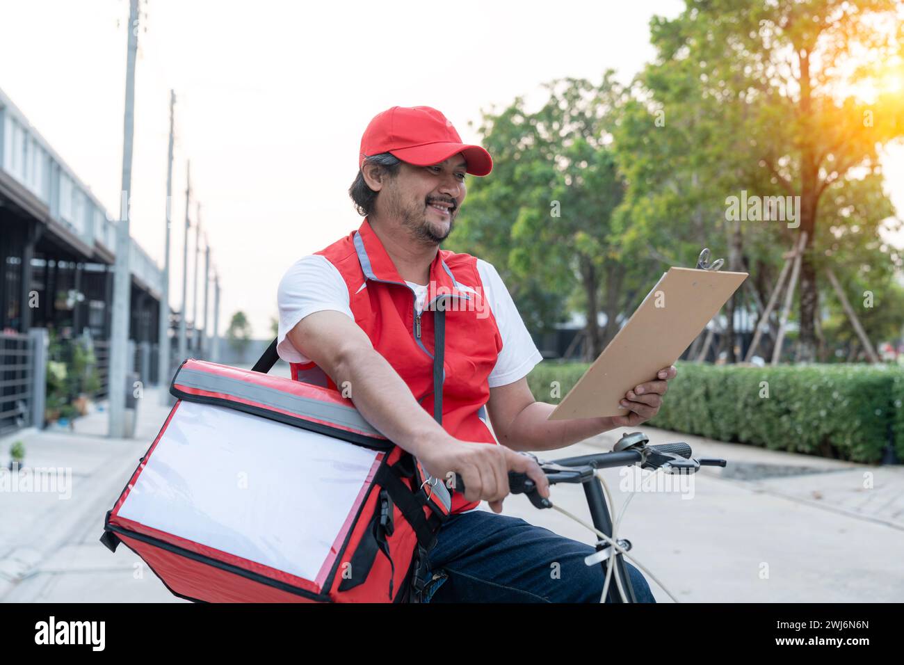 Delivery person riding a bicycle for food delivery Stock Photo