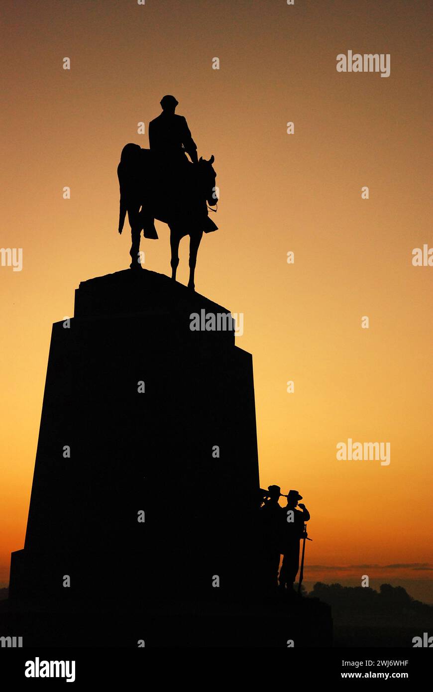 A sculpture of Confarreate General Robert E Lee on horseback stands in silhouette against the sunrise sky Stock Photo