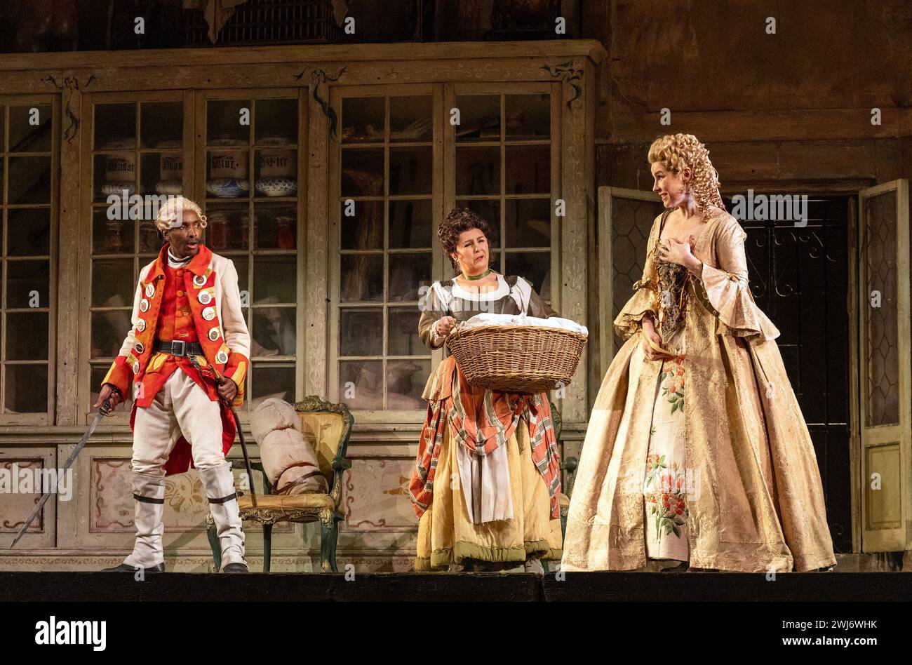 l-r: Innocent Masuku (Count Almaviva), Lesley Garrett (Berta), Anna Devin (Rosina) in THE BARBER OF SEVILLE at English National Opera (ENO), London Coliseum, London WC2  12/02/2024  music: Gioachino Rossini  libretto: Cesare Sterbini  conductor: Roderick Cox  design: Tanya McCallin  original lighting: Tom Mannings  original director: Jonathan Miller Stock Photo