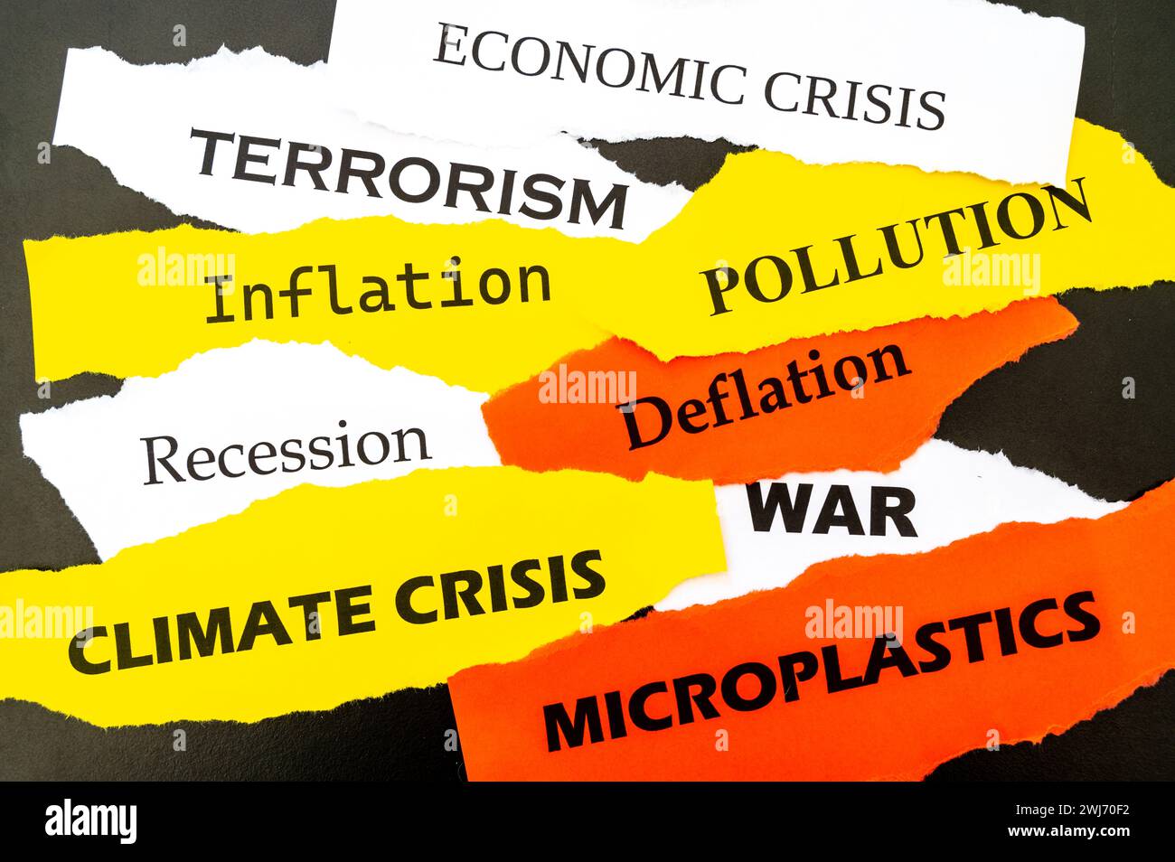 Current affairs, sheets of various colors with words: economic crisis, war, inflation, terrorism, etc., on a black background. Stock Photo