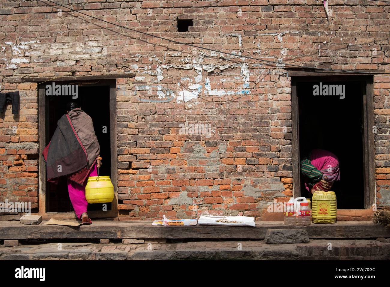 Kathmandu, Nepal- April 20,2023 : Women wash clothes and dishes on the streets of Patan Durbar Square. Stock Photo