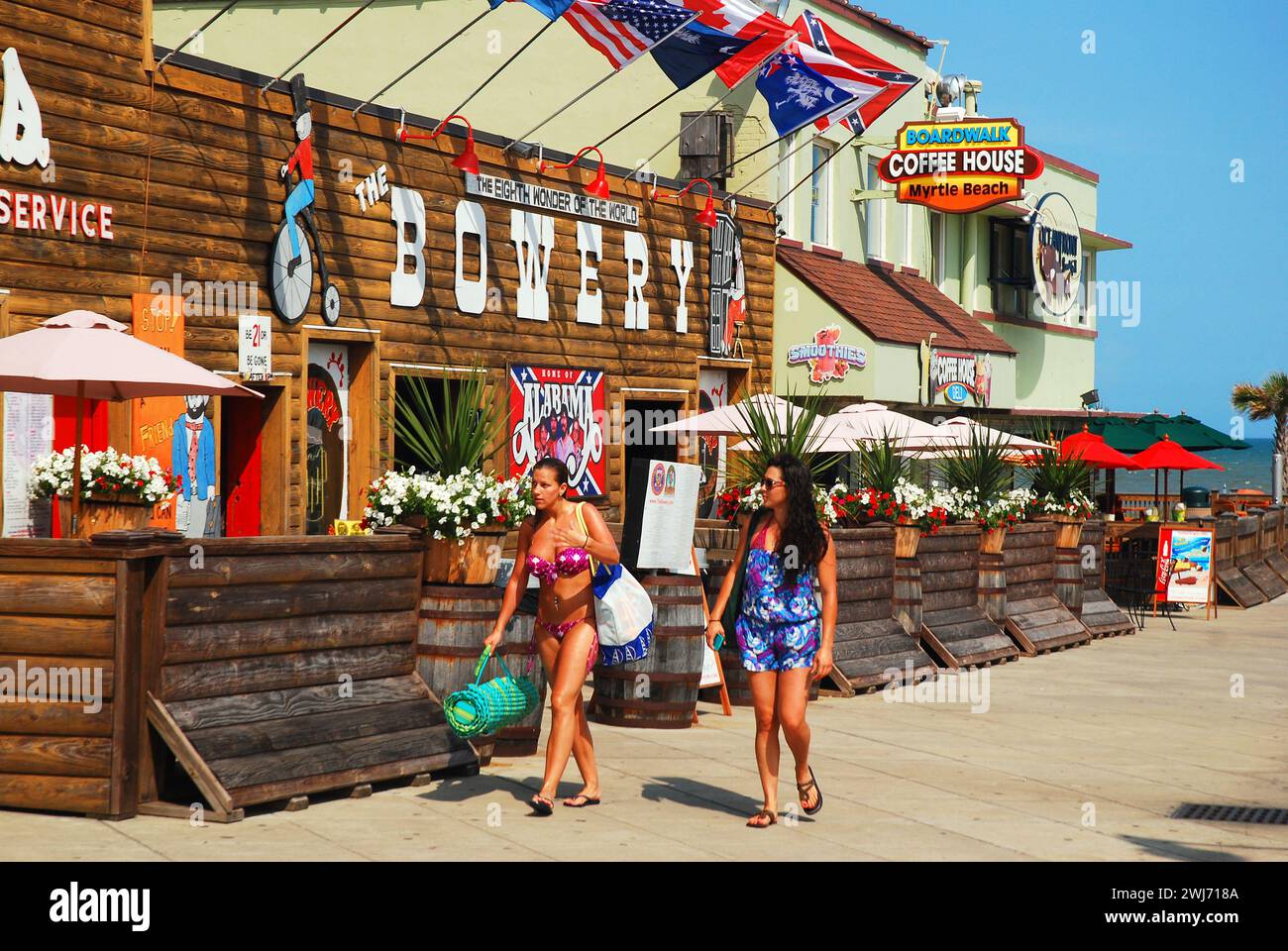People walk past the Bowery a legendary country music club on the boardwalk in Myrtle Beach, South Carolina Stock Photo