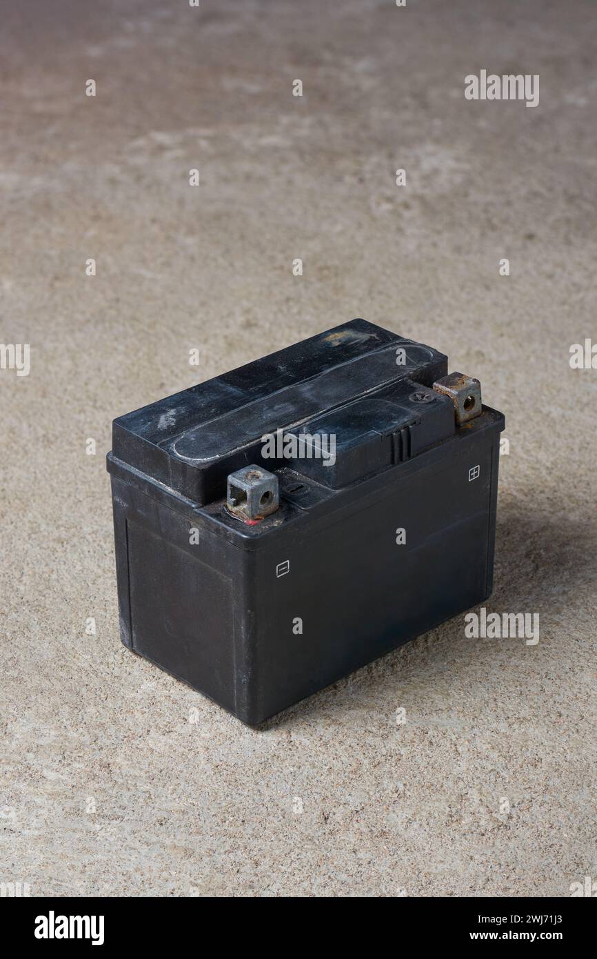 old discarded motorcycle battery, used lead acid battery on concrete