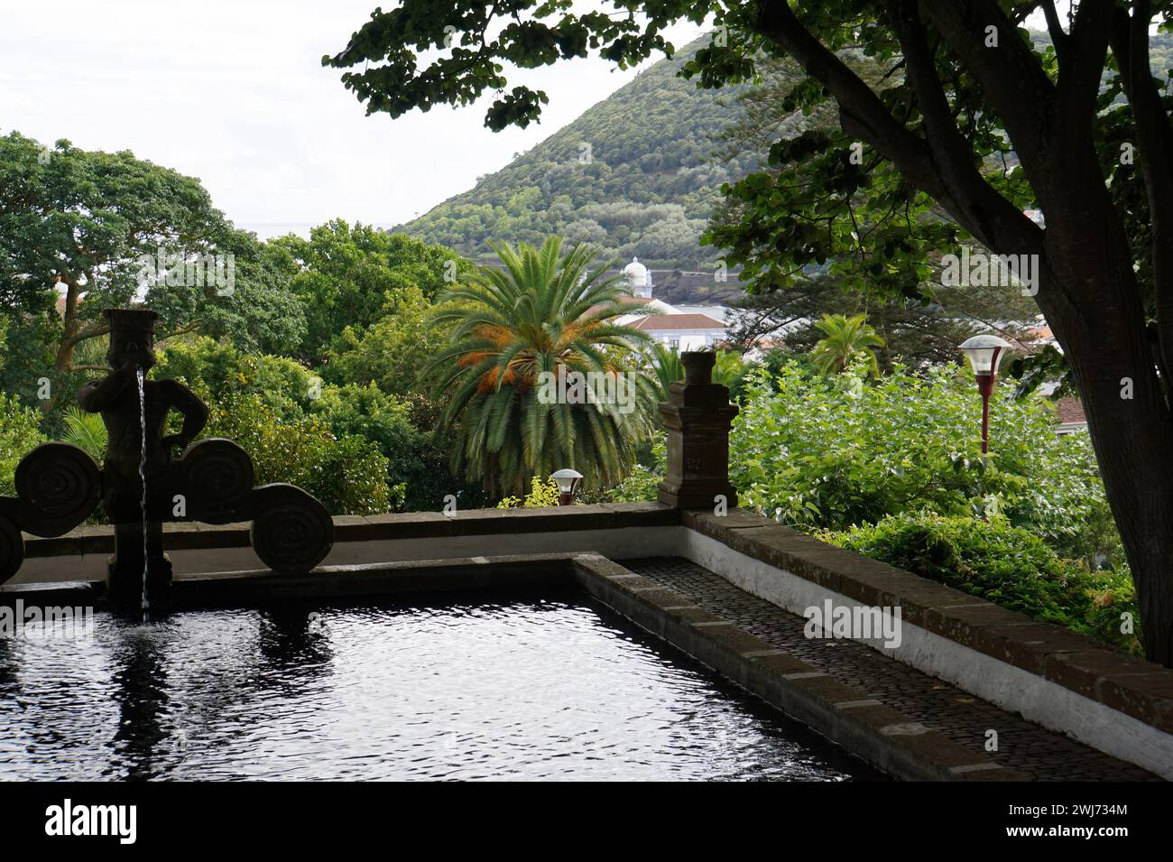 Um pequeno lago com árvores e montanhas ao fundo em Ilha de Terceira, Açores Stock Photo