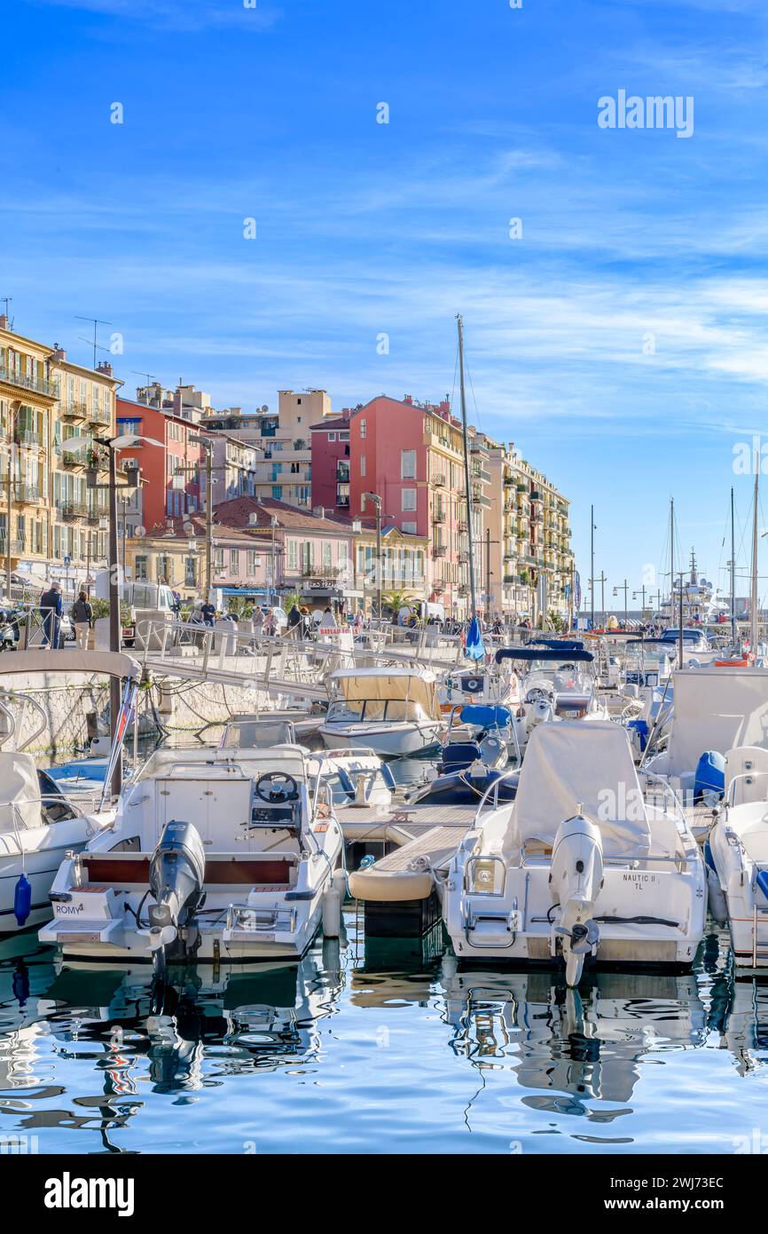 Picturesque Port Lympia in Nice. With luxury yachts and colourful rowing boats called 'pointus'. Used as fishing boats and now used by families too. Stock Photo