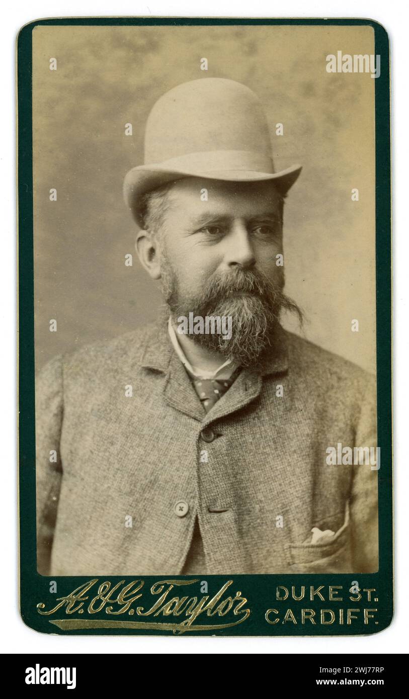 Original Victorian CDV  Carte de Visite ( visiting card or CDV) of pleasant looking bearded Welsh Victorian man gentleman wearing a light-coloured bowler hat with a high crown, a 'sack suit', fastened at the top, tie, hanky pocket (new in the 1880's) From the studio of A & G Taylor, Duke St, Cardiff, Wales U.K. circa mid 1880's. Stock Photo