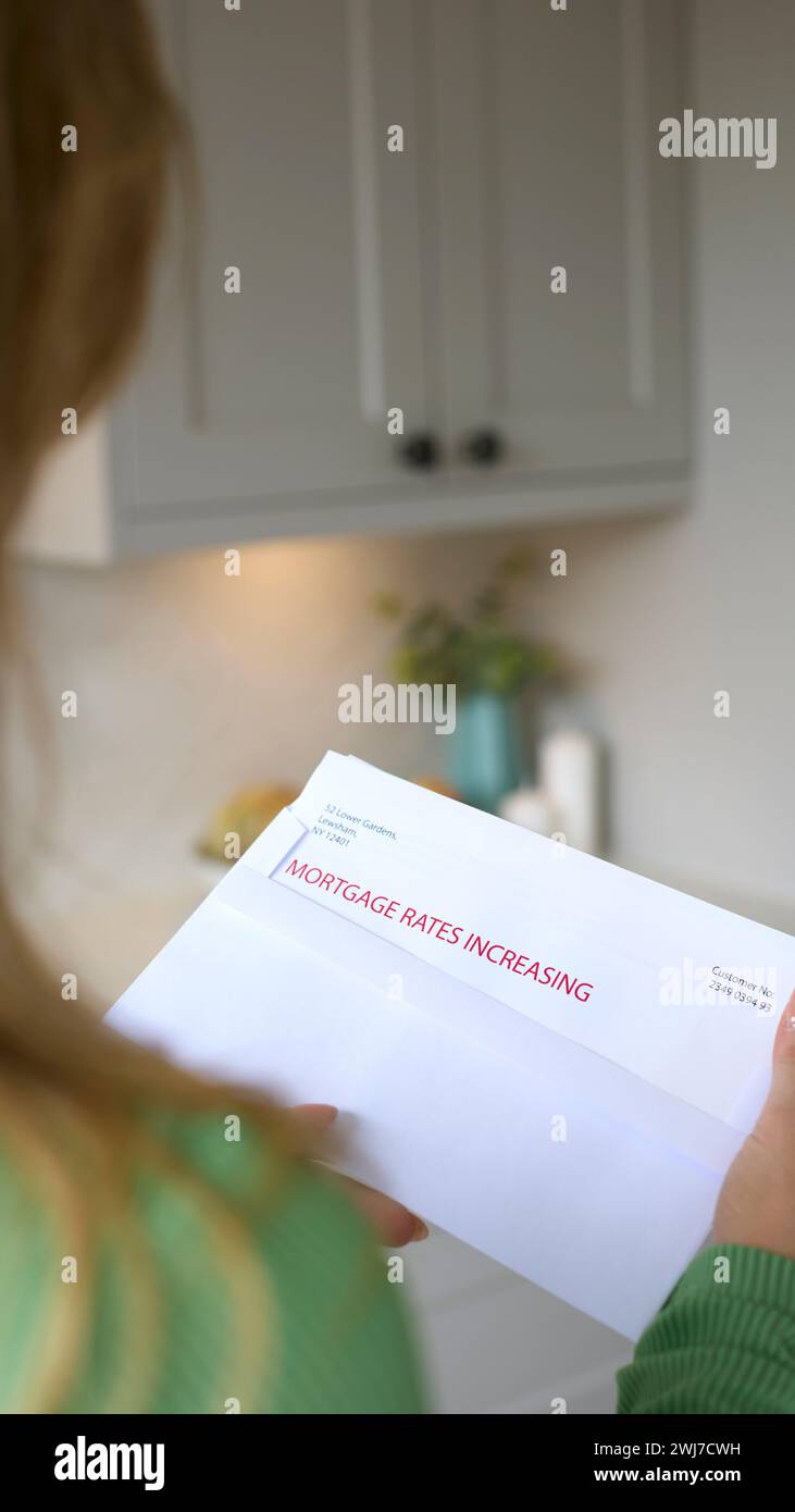 Close Up Of Woman Opening Letter About Increase in Mortgage Rate During Cost Of Living Crisis Stock Photo