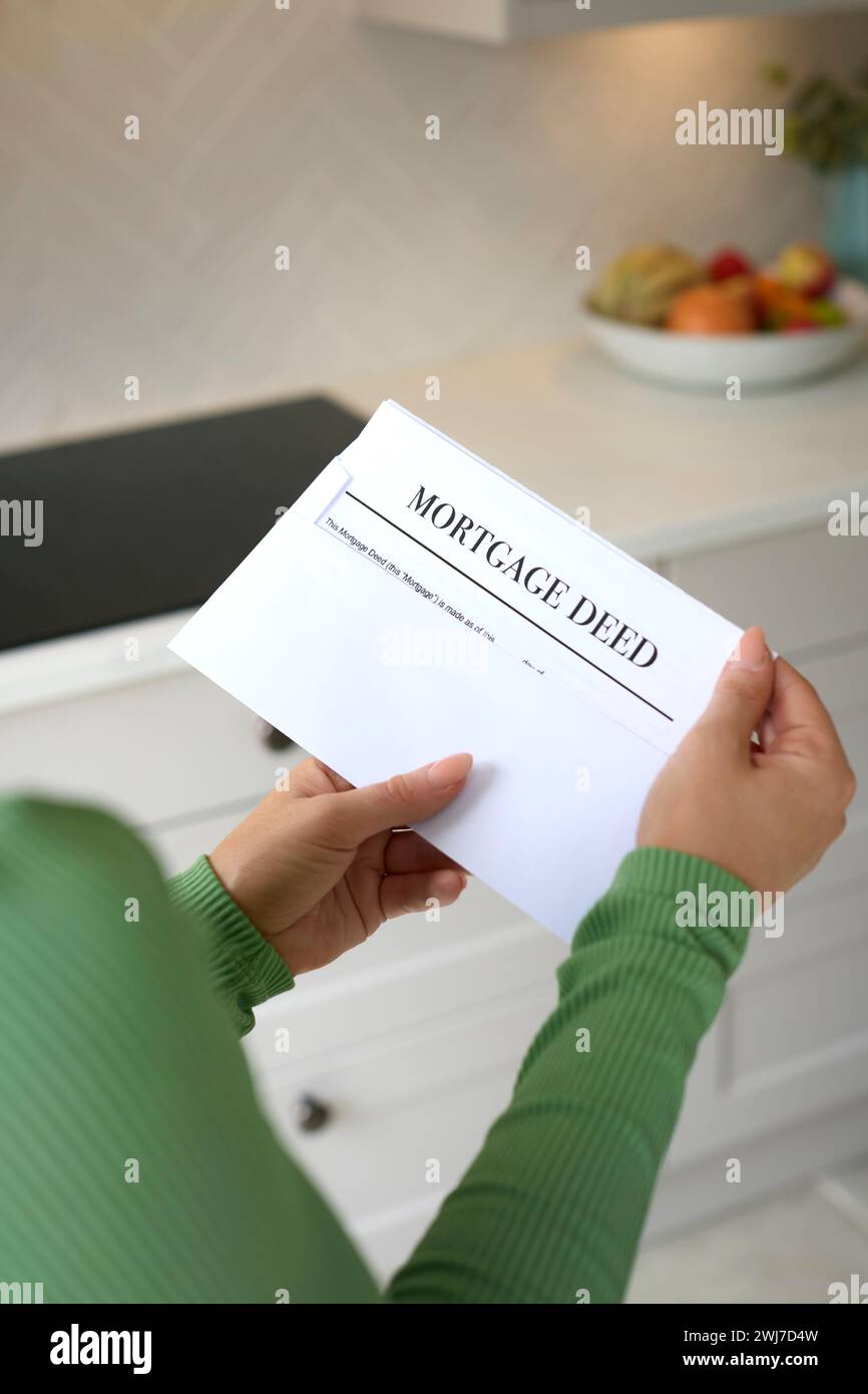 Close Up Of Woman Opening Letter Containing House Mortgage Deed Stock Photo
