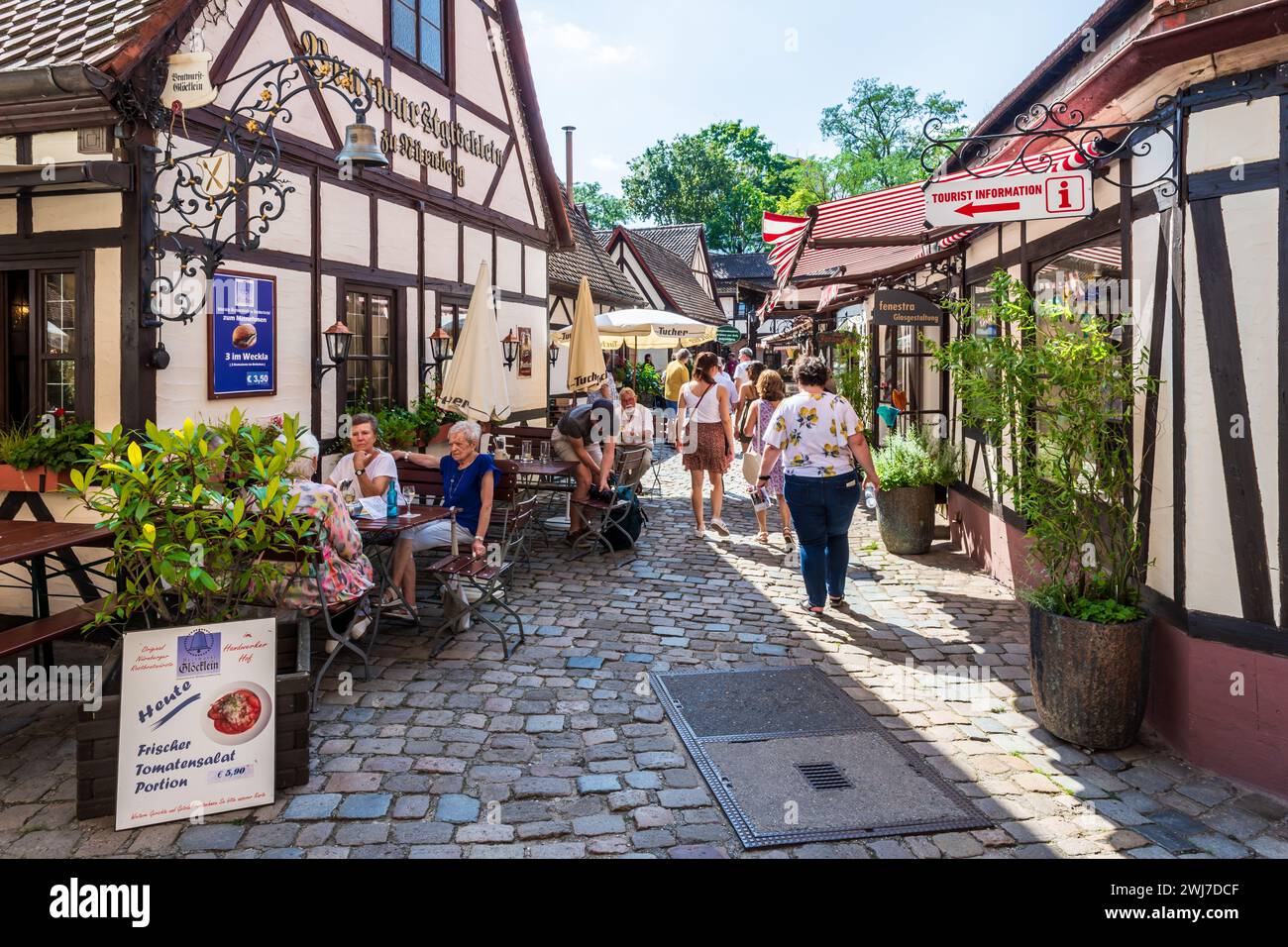 Tourists enjoy the restaurants' terraces and craft shops in the Handwerkerhof in Nuremberg, Germany, a craftmen's yard set in the old town. Stock Photo