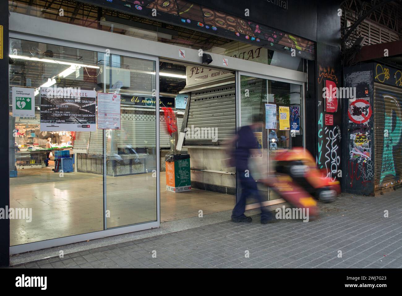 Man getting a children ride into the old Abaceria Central Market during the closing time in Barcelona Stock Photo