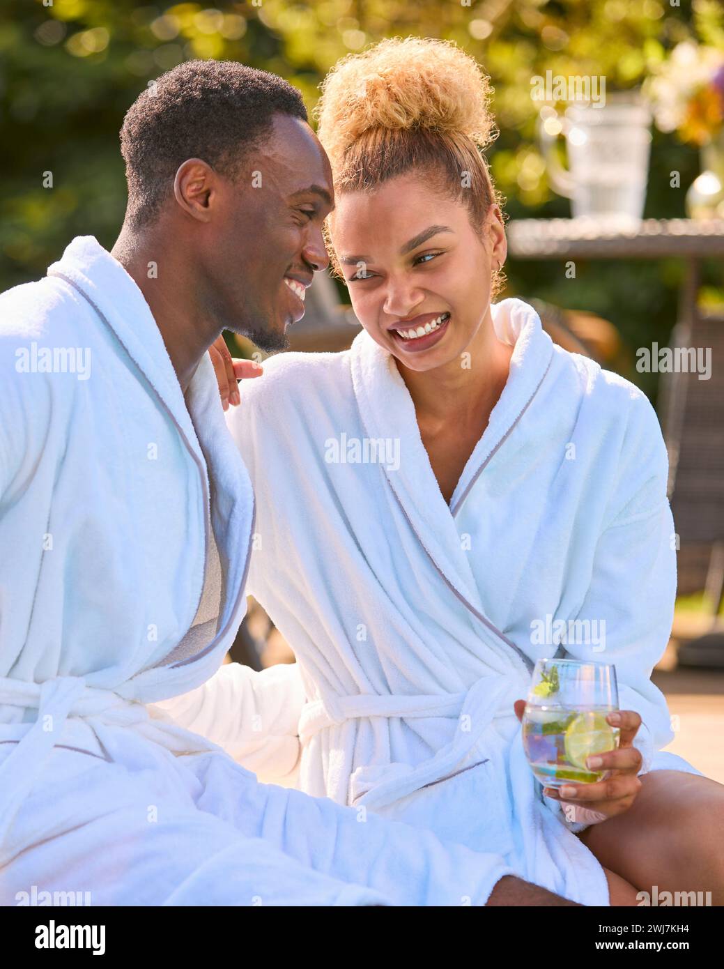 Happy Loving Couple Wearing Robes Outdoors With Drinks On Spa Day Stock ...