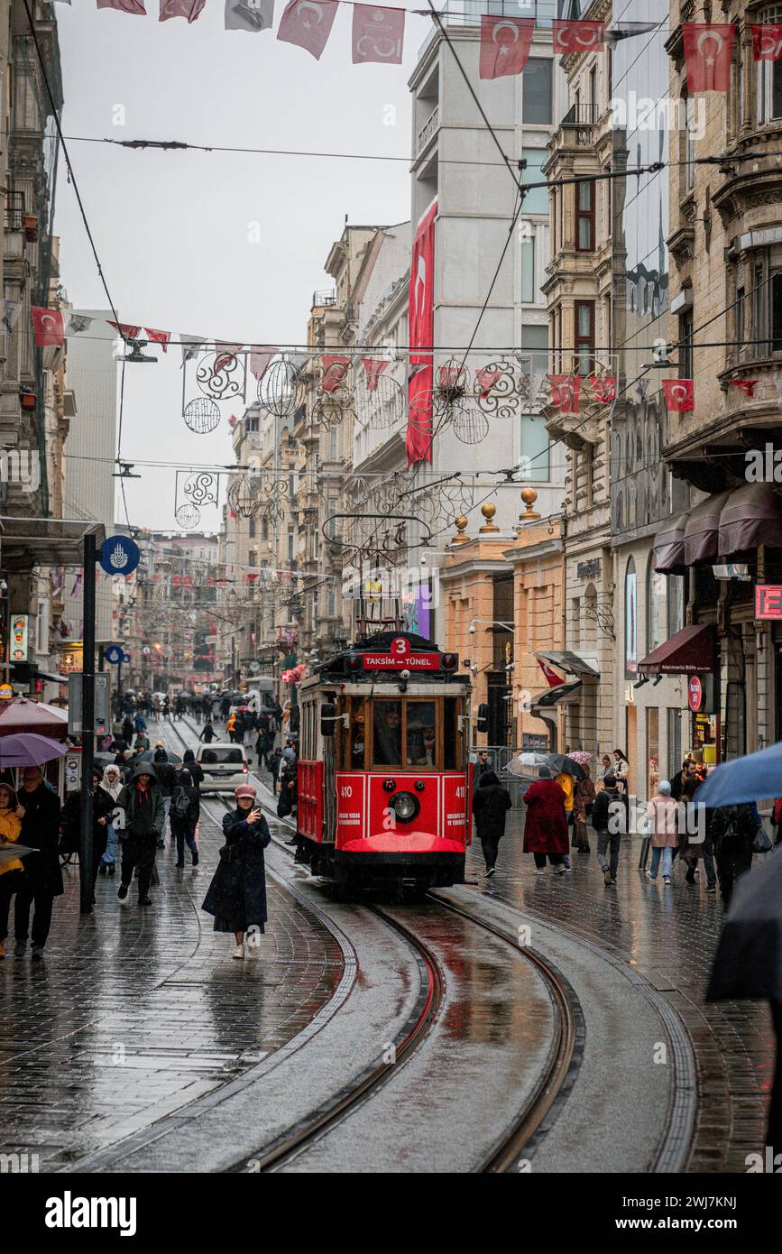 Rainy Rendezvous: The Red Tram of Istanbul's Wet Streets Stock Photo