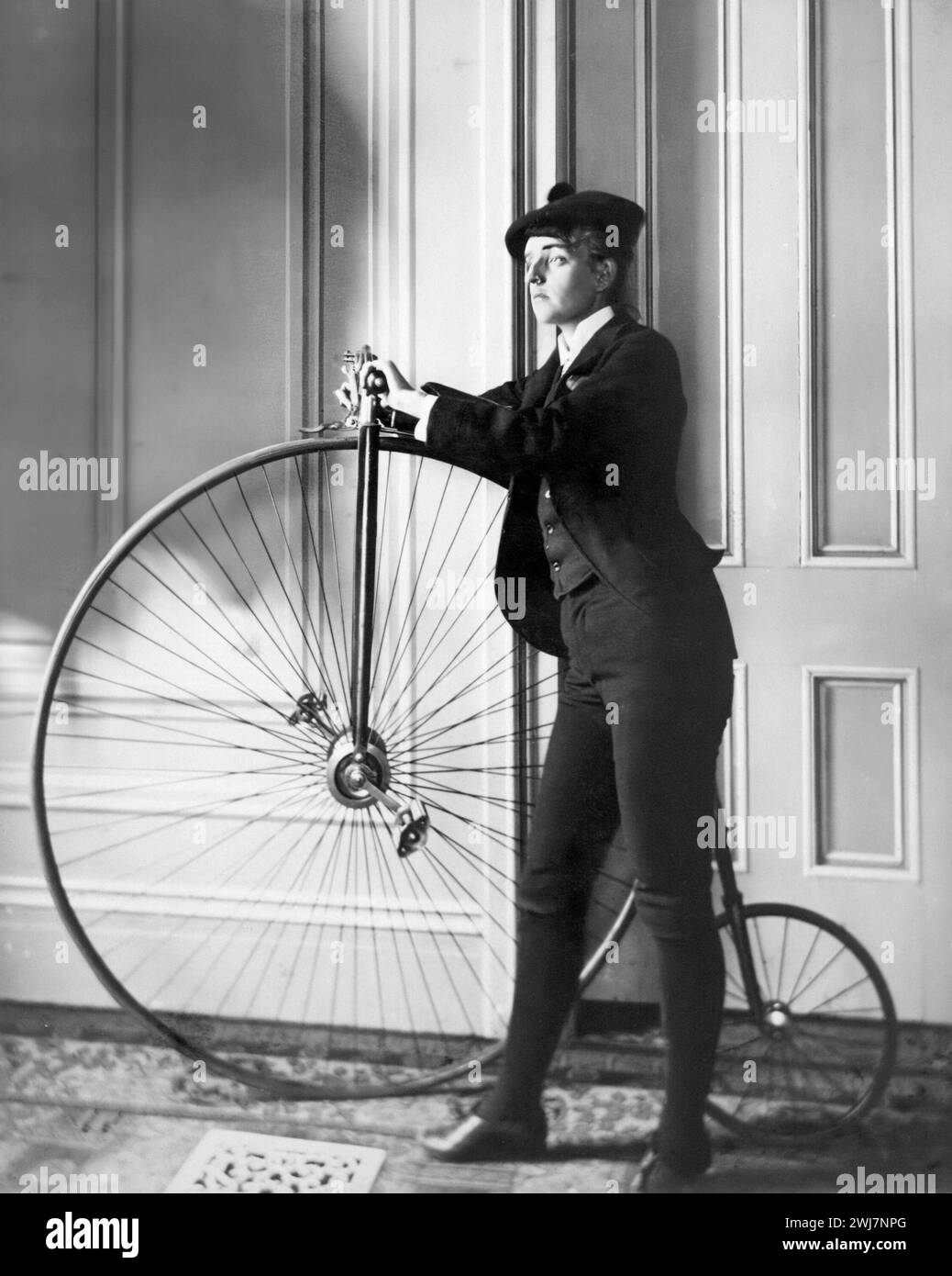 Penny Farthing. Frances Benjamin Johnson standing next to a penny farthing, c. 1890-1900 Stock Photo
